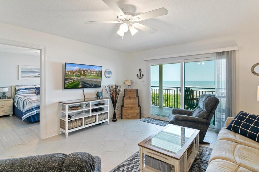 a living room with a couch and a tv at Windjammer 209 in St. Augustine