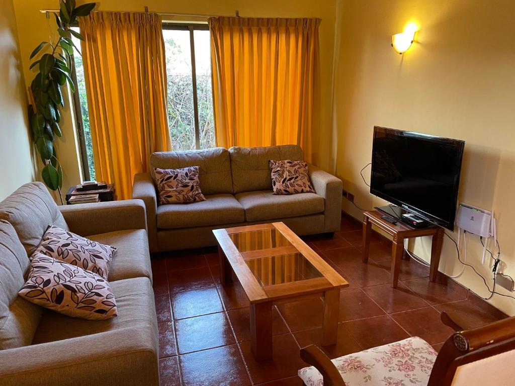 a living room with a couch and a tv at Casa confortable, campo y playa in Buchupureo