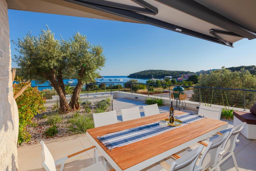 a dining table and chairs on the balcony of a house at Resort Banjole - apartman Indigo in Banjole
