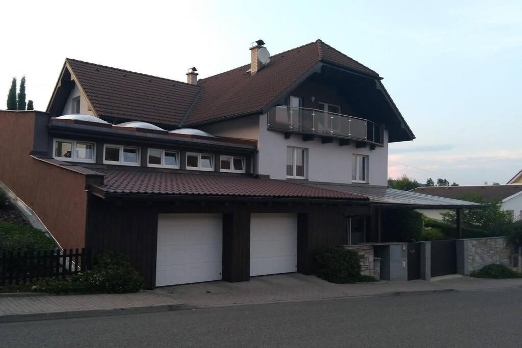 a house with two garage doors and a roof at Světlá nad Sázavou dům s výhledem in Světlá nad Sázavou