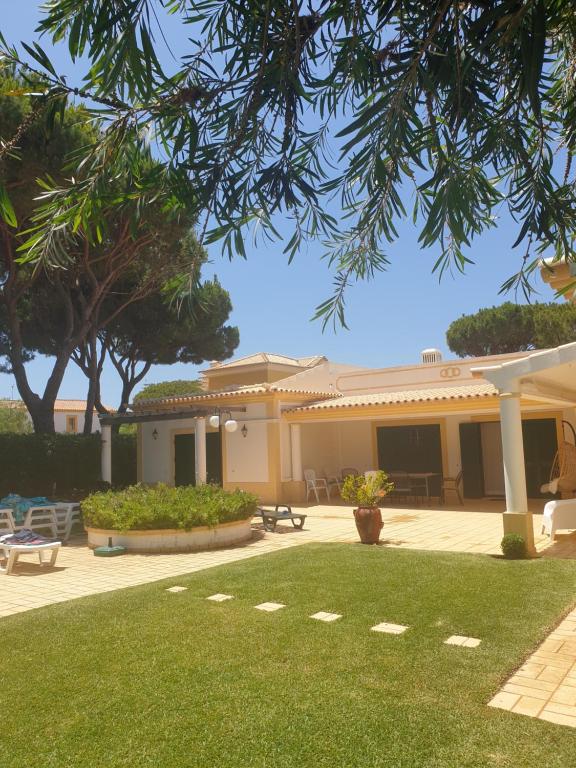 una casa con césped delante en The Pinewood Villa, en Vilamoura