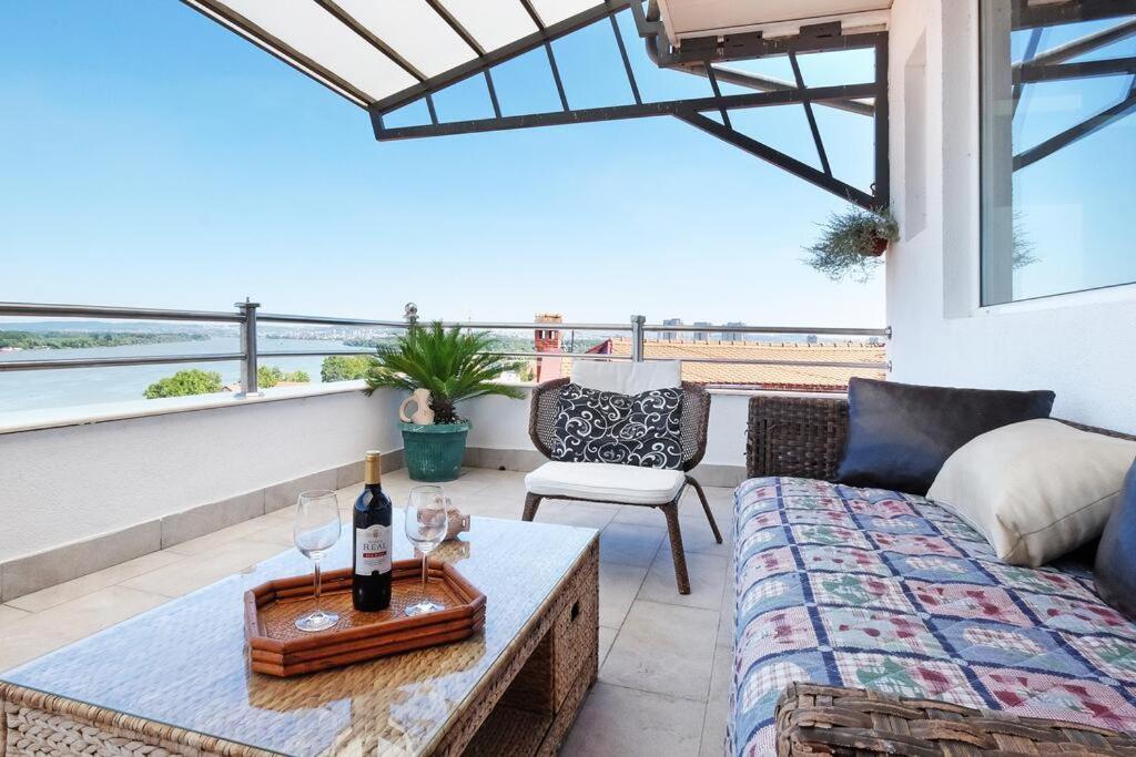 a living room with a couch and a table with wine glasses at Villa Tower Gardos in Belgrade