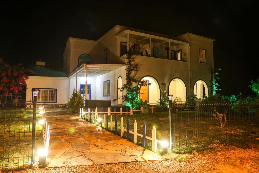 a house with lights in front of it at night at Yalıyanı Pansiyon in Yaliciftlik