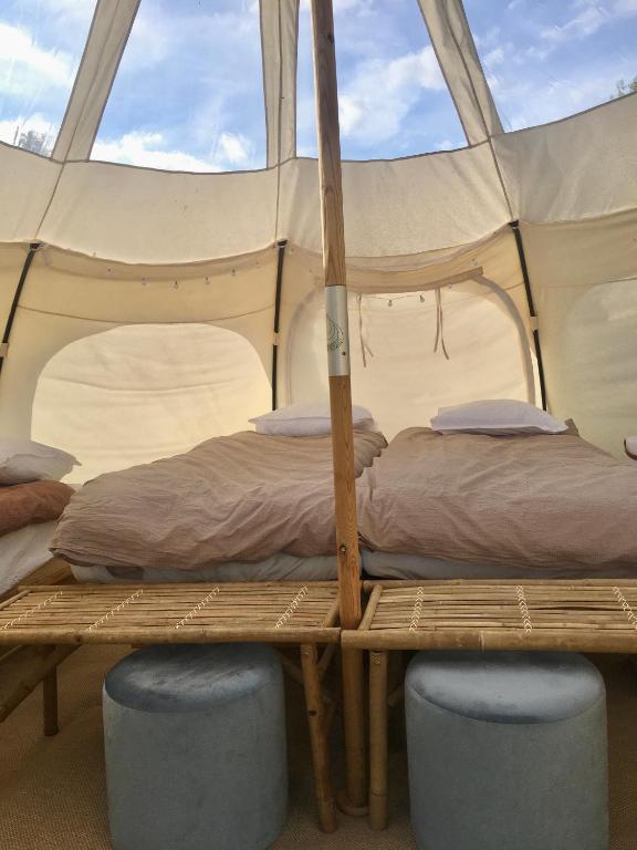 a bedroom with two beds in a tent at Hvidegaard Møn in Stege