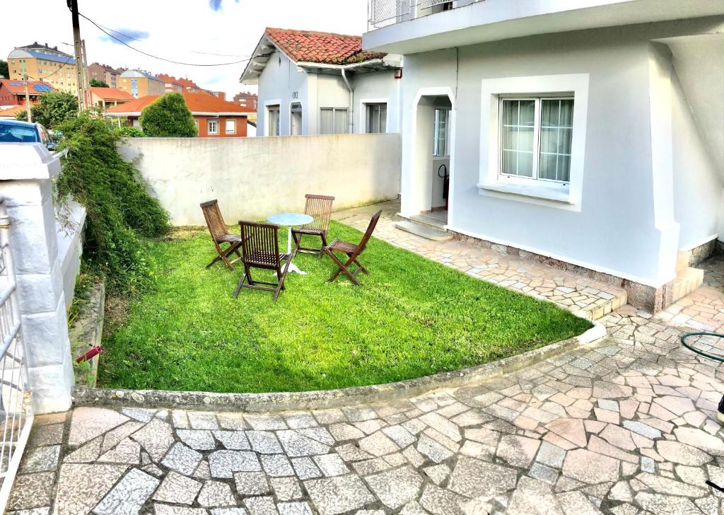 a patio with a table and chairs in a yard at La casita de El Montan Baja in Avilés