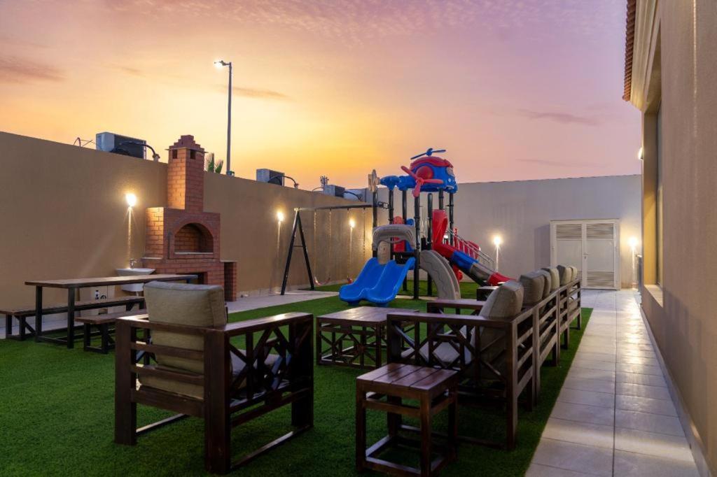 a playground with a table and chairs on a roof at forsana resort in Dammam