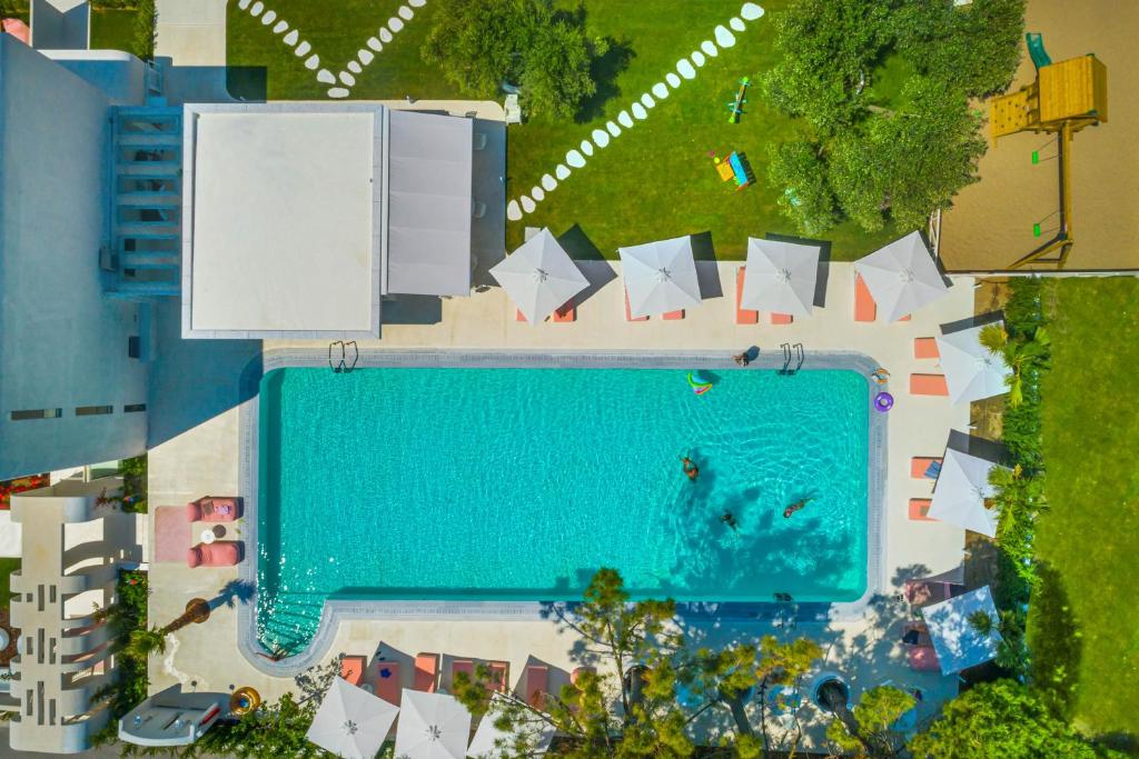 an overhead view of a swimming pool with umbrellas at Cocoοns Luxury Suites & Villas in Fourka