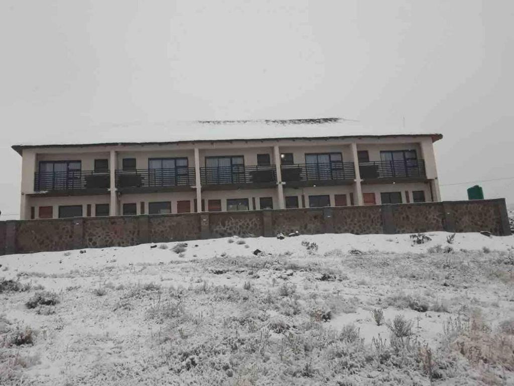 a building on top of a snow covered hill at Highlands Lodge in Mokoeng