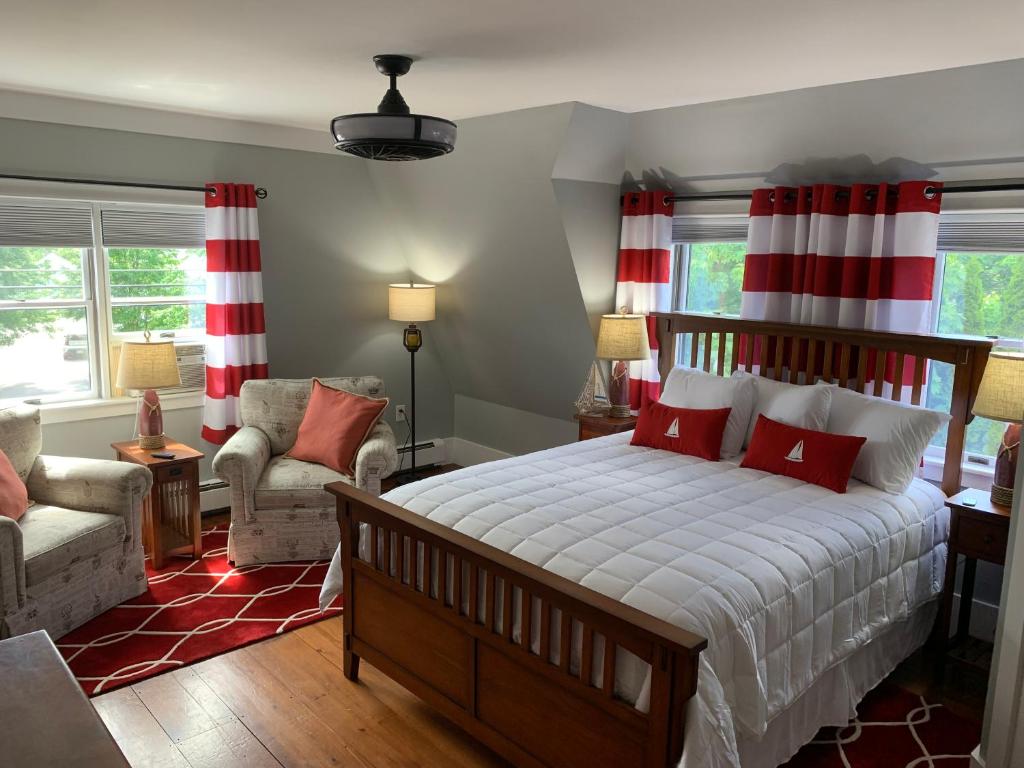 een slaapkamer met een groot bed met rode en witte strepen bij White Sails Inn in Kennebunk