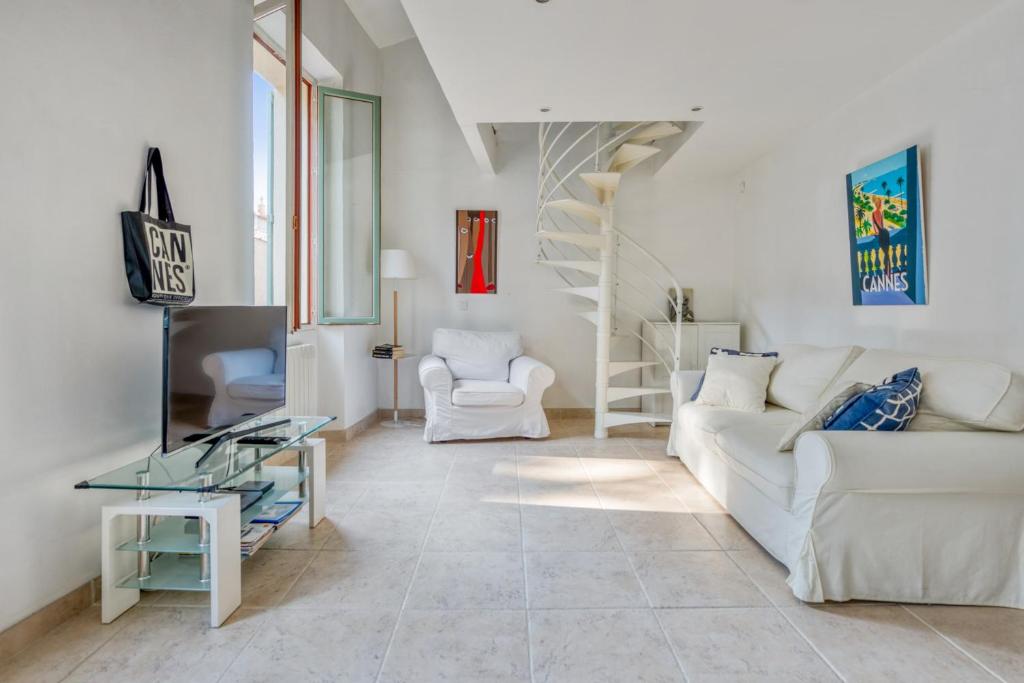 un salon avec un canapé blanc et une télévision dans l'établissement Magnifique appartement proche de la plage au coeur de Cannes - Welkeys, à Cannes