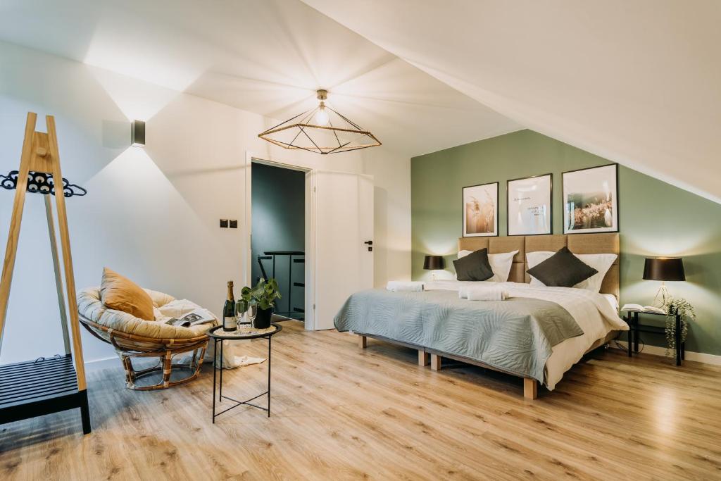 a bedroom with a king sized bed and a chair at Rezydencja Bieszczady - Solina in Solina