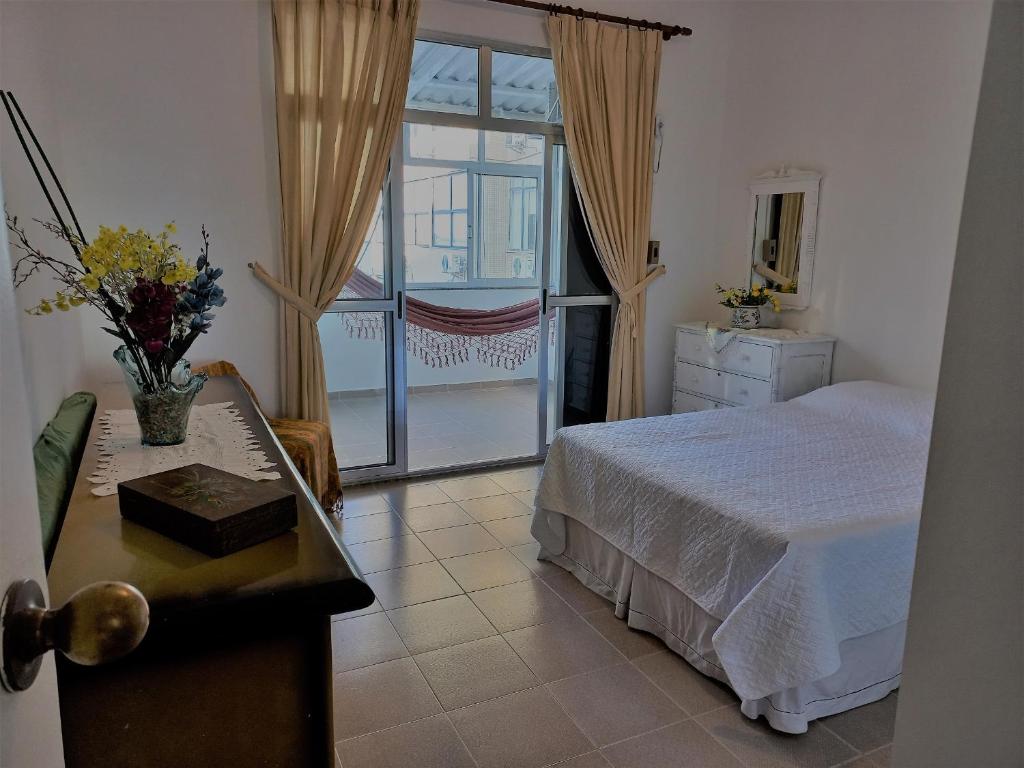 a bedroom with a bed and a table and a window at Mommy's Apartment in Copacabana in Rio de Janeiro