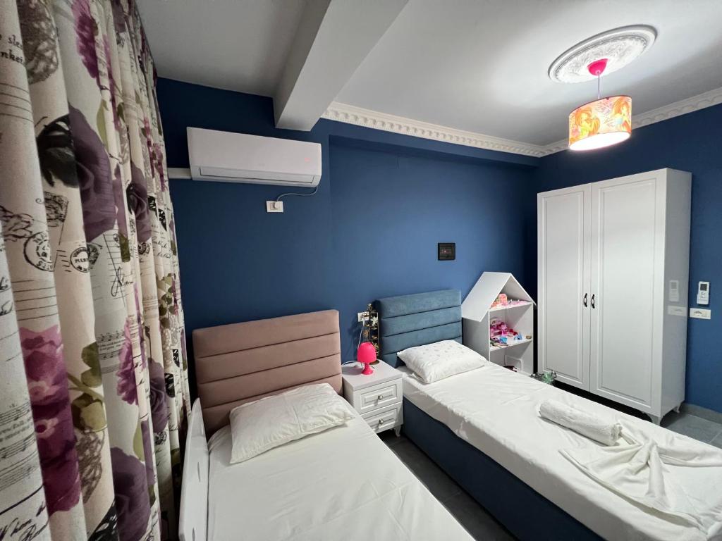 2 camas en una habitación con paredes azules en Apartment rent Elbasan city center 1 en Elbasan