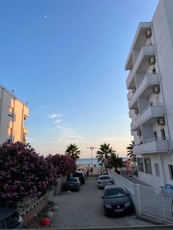 une rue avec des voitures garées à côté d'un bâtiment dans l'établissement Flors Apartments, à Durrës