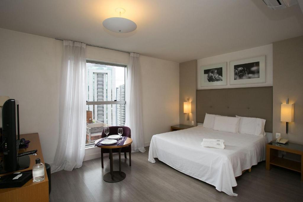um quarto de hotel com uma cama e uma janela em Locking's Santo Agostinho 9 em Belo Horizonte