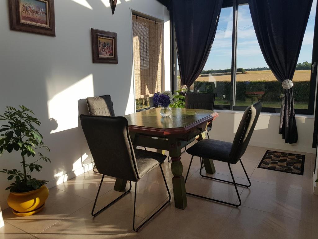 a dining room with a wooden table and chairs at Calme et Nature in Rouen