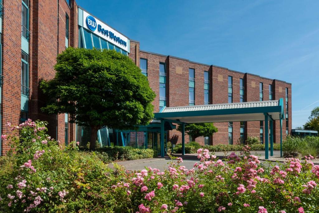 a brick building with flowers in front of it at Best Western Parkhotel Brehna-Halle in Brehna