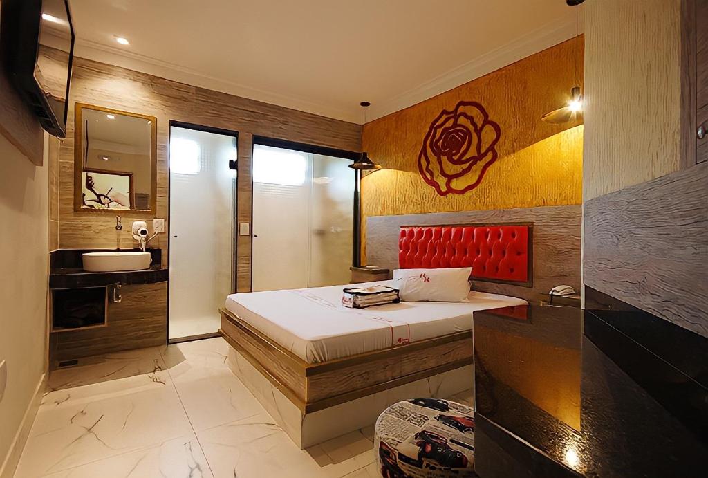 ein Schlafzimmer mit einem Bett und einem Waschbecken in einem Zimmer in der Unterkunft Red Rose Motel & hotel in Franco da Rocha