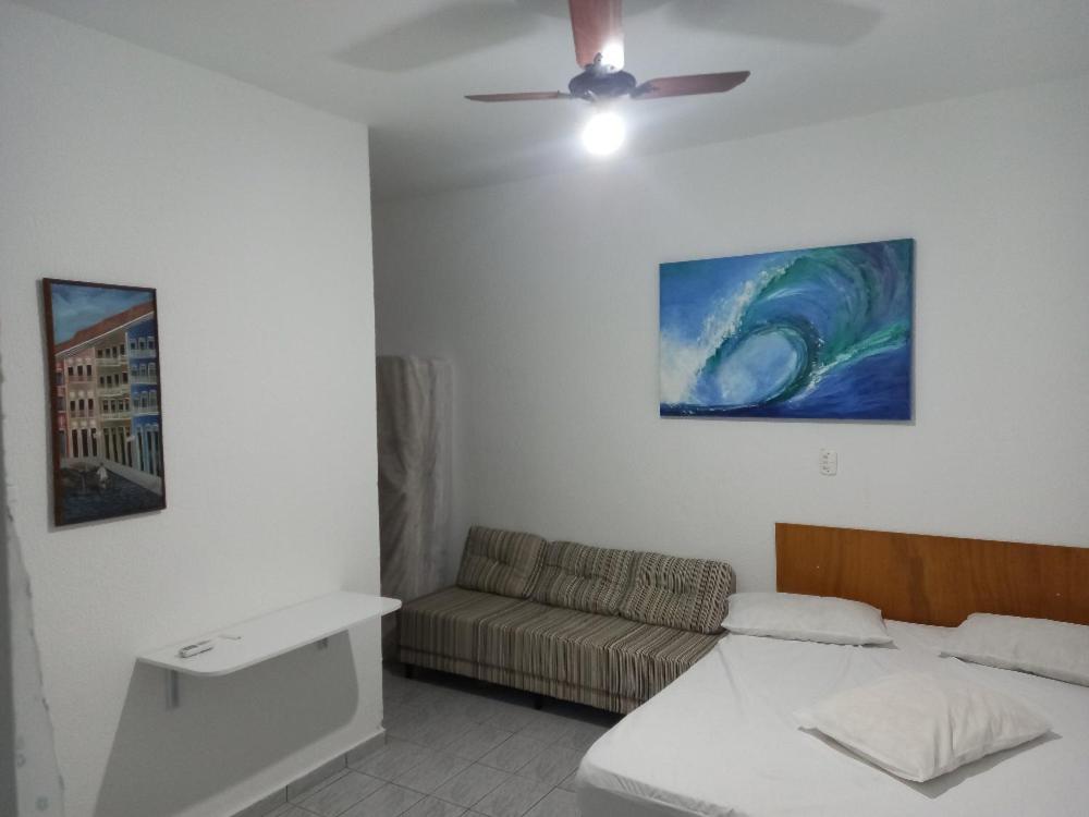 ein Wohnzimmer mit einem Bett und einer Couch in der Unterkunft Chalé do Tio Beto - Caraguatatuba in Caraguatatuba