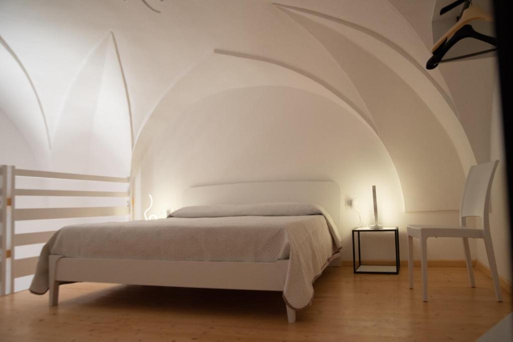 biała sypialnia z łóżkiem i stołem w obiekcie Al muro casa vacanza w mieście Leverano