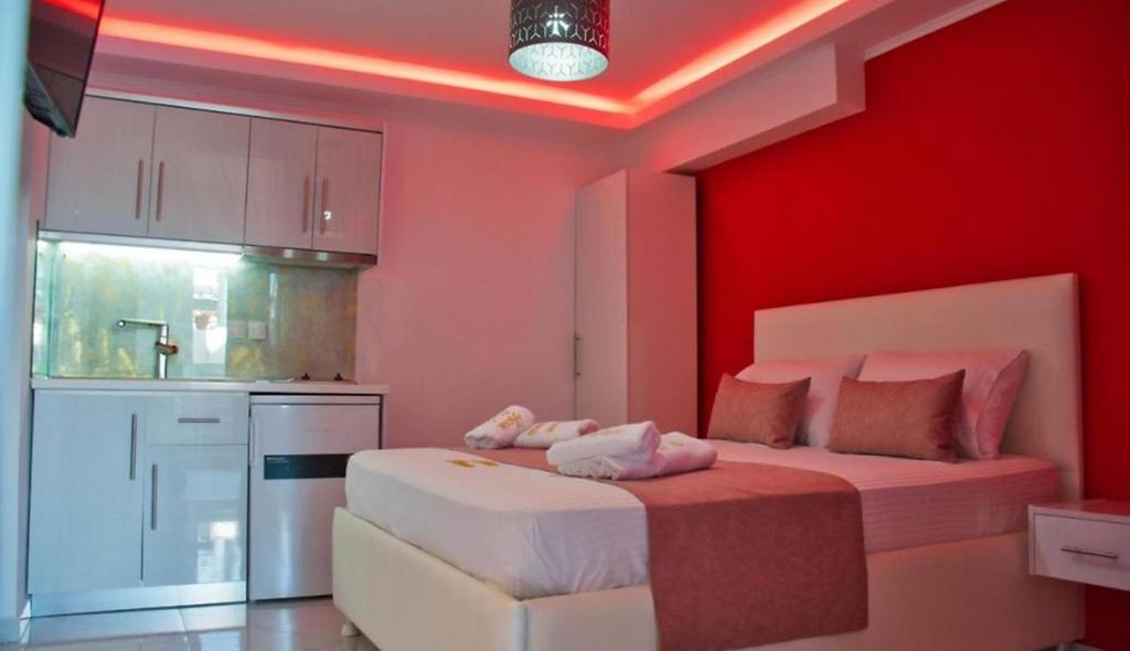 a bedroom with red walls and a bed with white sheets at House Blerina in Sarti