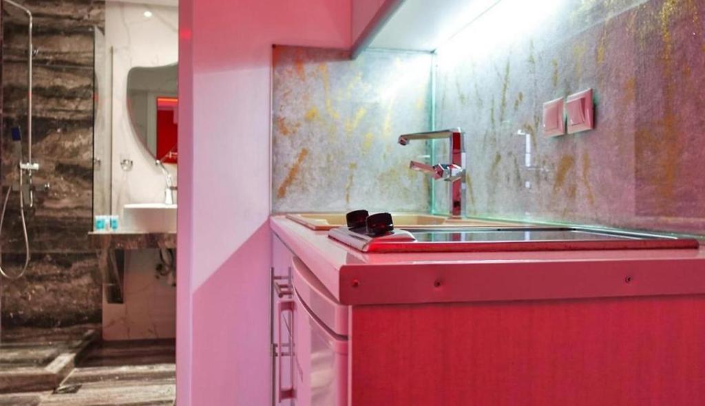 a pink kitchen with a sink and a sink at House Blerina in Sarti