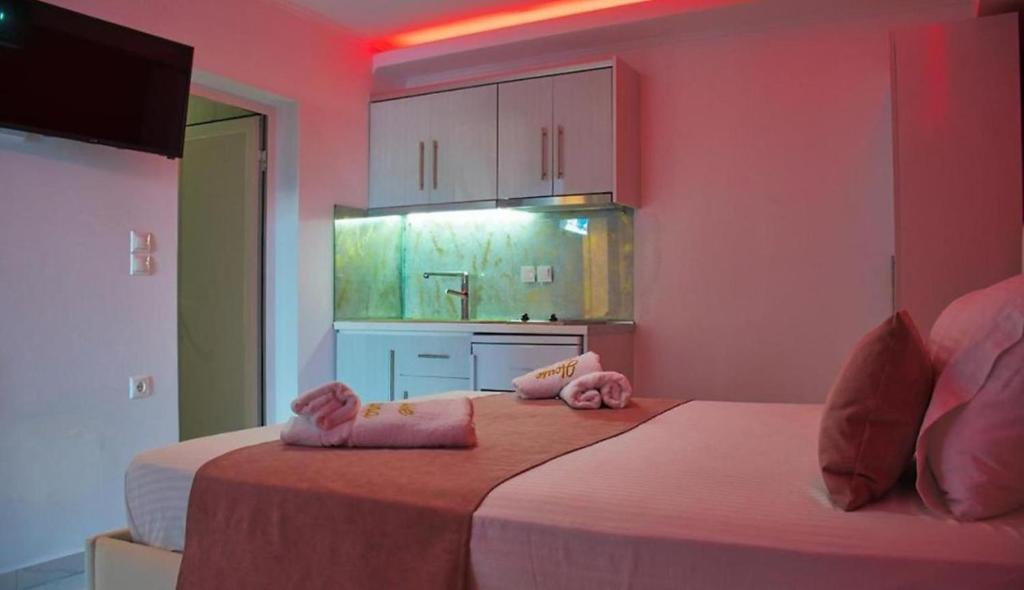a bedroom with two beds with pink walls and cabinets at House Blerina in Sarti