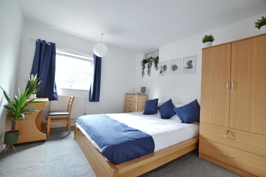 una camera da letto con un grande letto con cuscini blu di Garden Tower flat a Londra