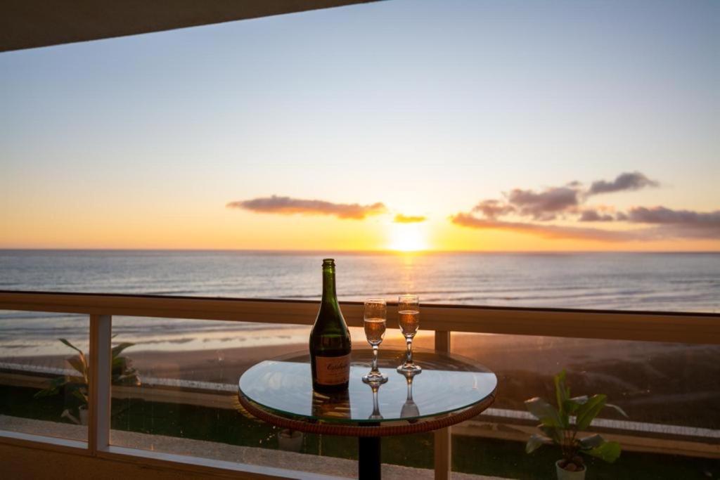 une bouteille de vin et deux verres sur une table sur un balcon dans l'établissement Departamento La Serena, Laguna del Mar, Vista Privilegiada, à La Serena
