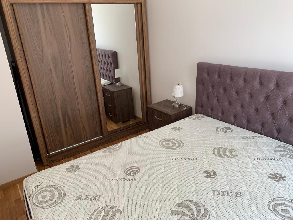 um quarto com uma cama, uma cadeira e um espelho em Apartman A2 em Ulcinj