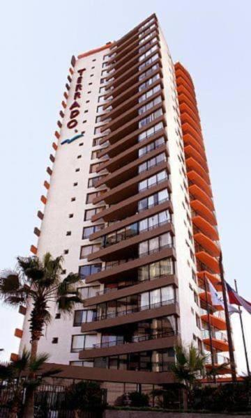a tall apartment building with an orange at Amoblados MyK playa brava club in Iquique