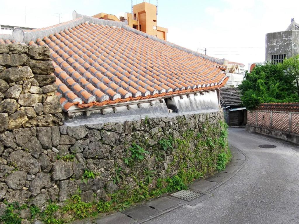 a stone wall with a roof on top of it at Hotel Abest Naha Kokusaidori in Naha