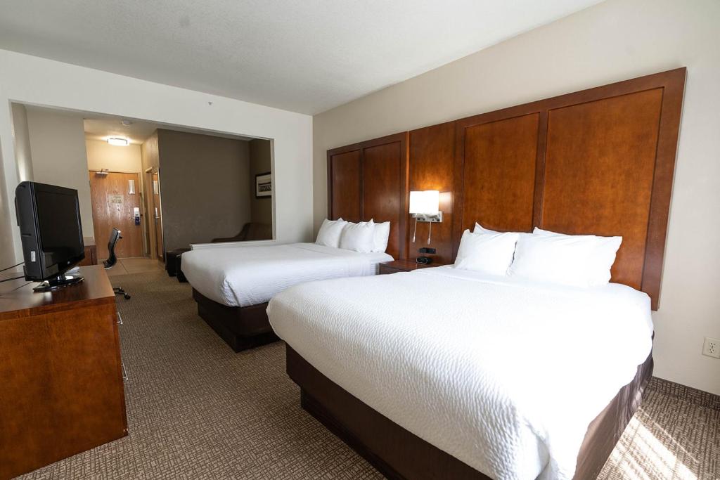 a hotel room with two beds and a flat screen tv at Rapid River Lodge in Baxter