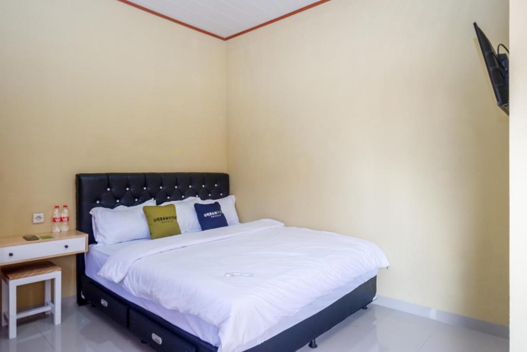 Giường trong phòng chung tại Urbanview Hotel Telu Wolu Monjali by RedDoorz