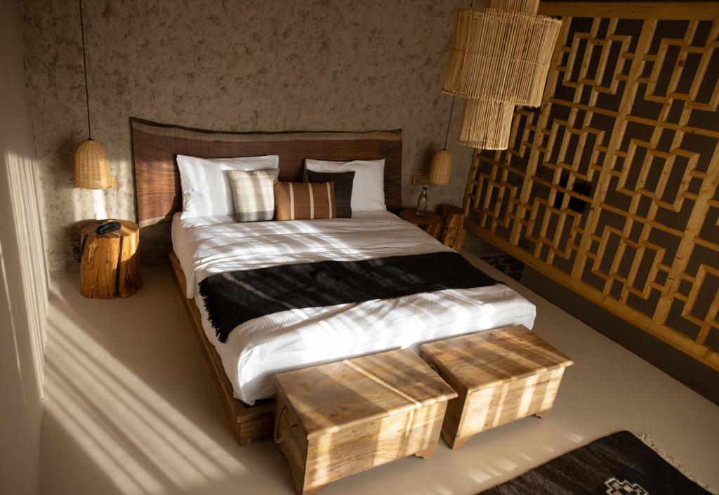 a bedroom with a large bed with a wooden box at Dolkhar Resort in Leh