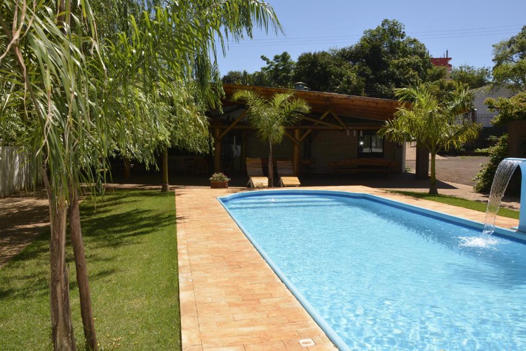 a swimming pool in a yard next to a house at Hotel Salzburgo in Ciudad del Este