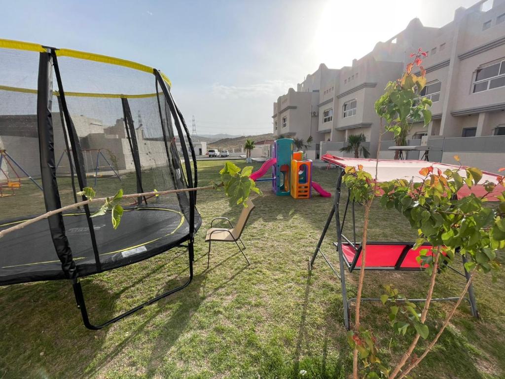 a group of chairs and a swing set in a yard at فلل السيف الخاصة in Abha