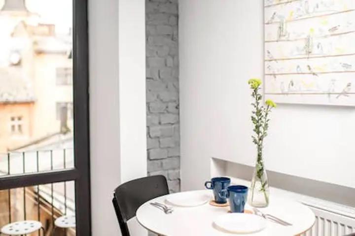 Art Apartments Rynok Square في إلفيف: طاولة بيضاء عليها إناء من الزهور