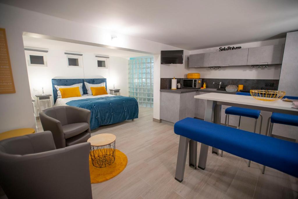 a bedroom with a blue bed and a kitchen at Rochecorbon Le Gite des Clouet "Labellisé Loire A Vélo" in Rochecorbon