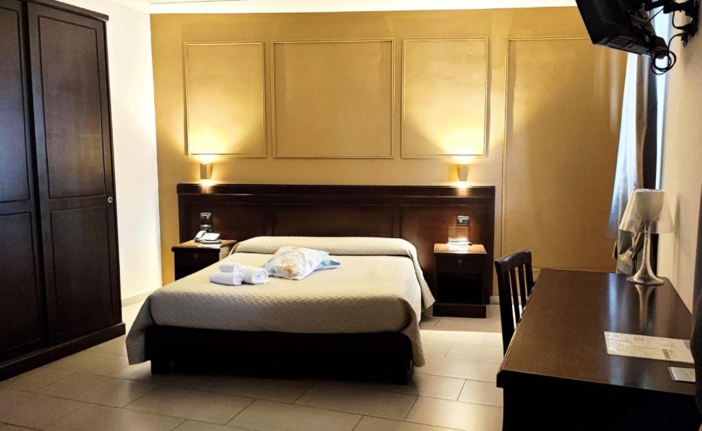 a bedroom with a bed and a table and a desk at Albanuova Hotel in Reggio di Calabria