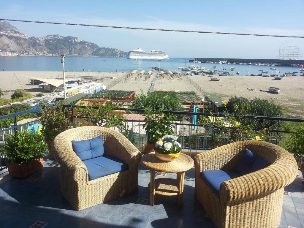 2 sillas y una mesa en un balcón con playa en Terrazza sul Mare, en Giardini Naxos