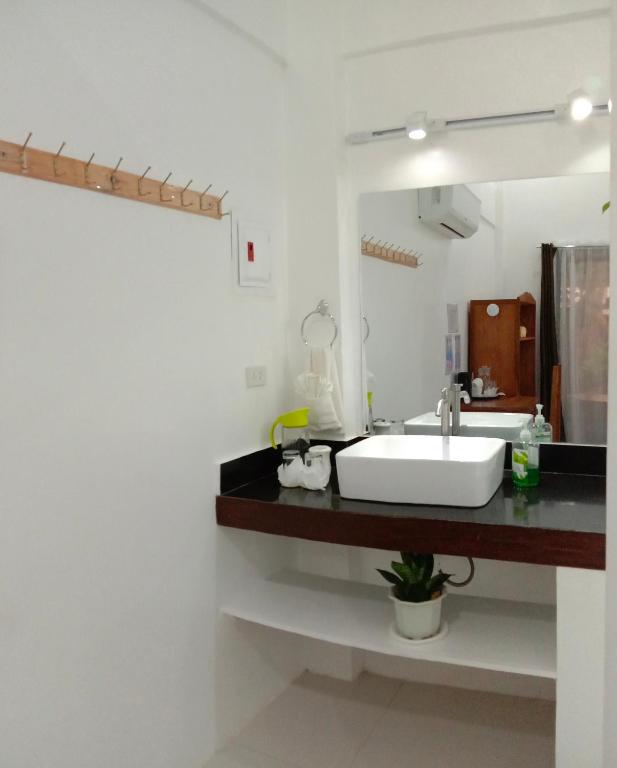Un baño con un lavabo blanco y un espejo. en Corong Beach Resort, en El Nido