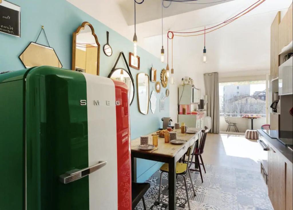 La cuisine est équipée d'une table et d'un réfrigérateur vert. dans l'établissement Croisette Beach Cannes Banane 4 sleeps Apart, à Cannes