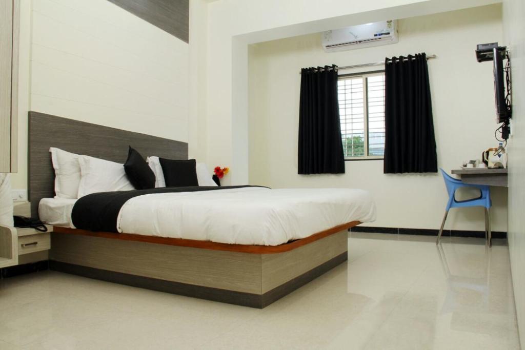 een slaapkamer met een bed en een bureau. bij HOTEL NEW BHARTI in Aurangabad