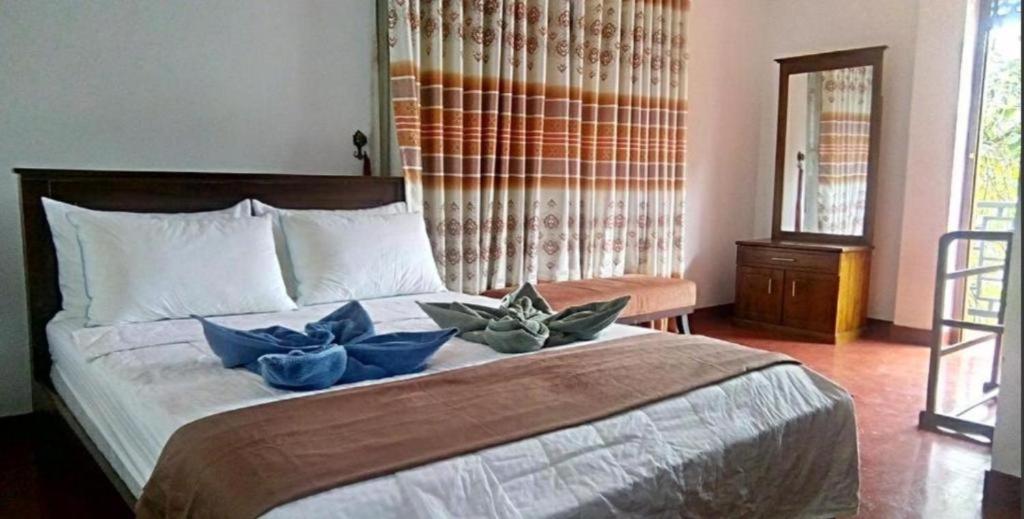 a bedroom with a large bed with blue flowers on it at Ramboda holiday Inn in Kotmale