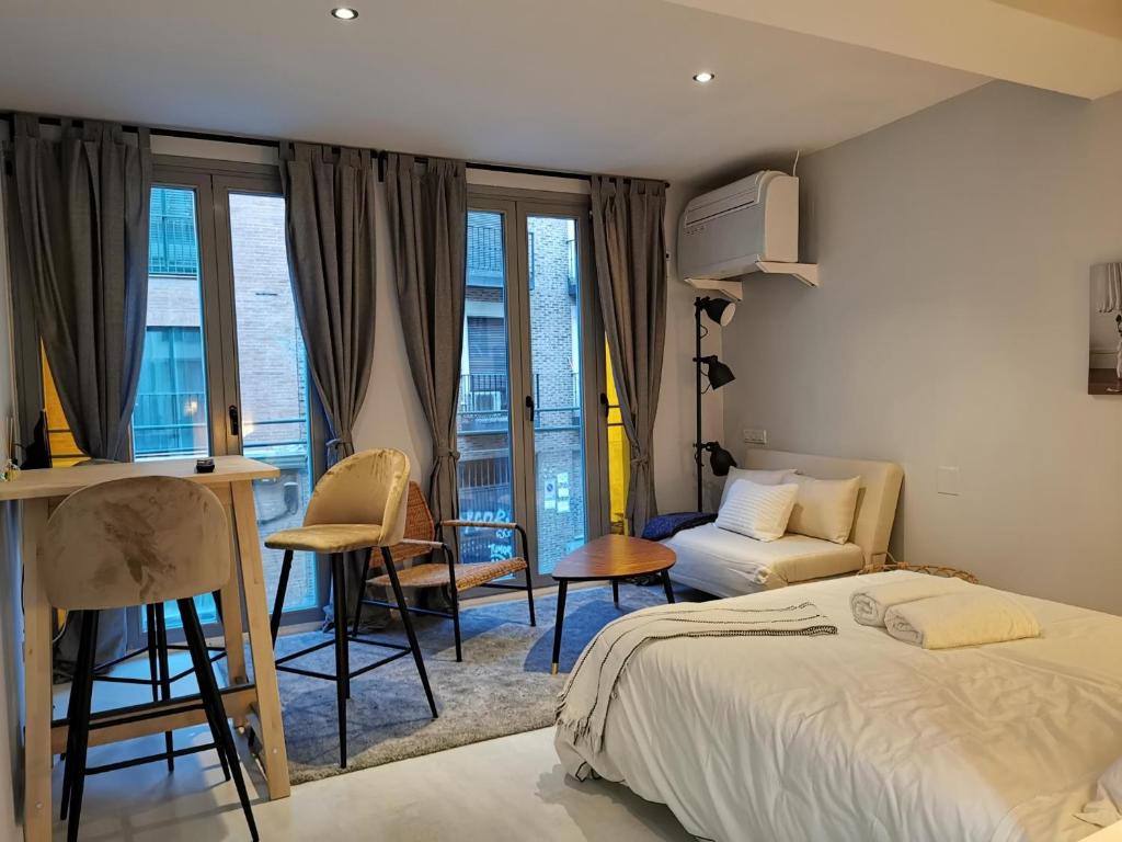 sypialnia z łóżkiem, stołem i krzesłami w obiekcie La Estancia de Leganitos w Madrycie