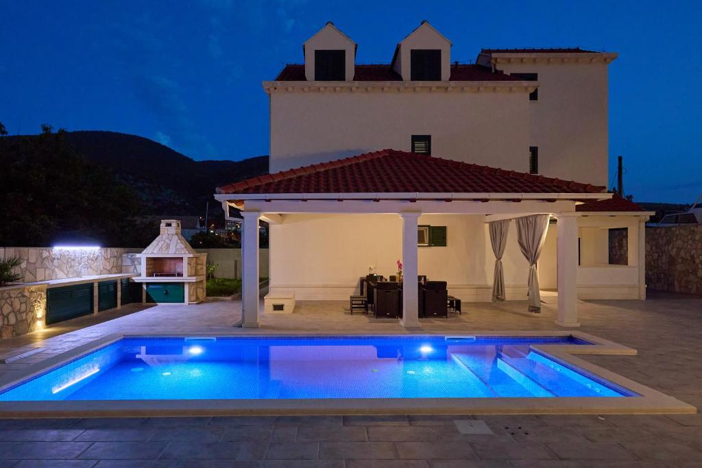 une villa avec une piscine la nuit dans l'établissement Villa Larum, à Mokošica