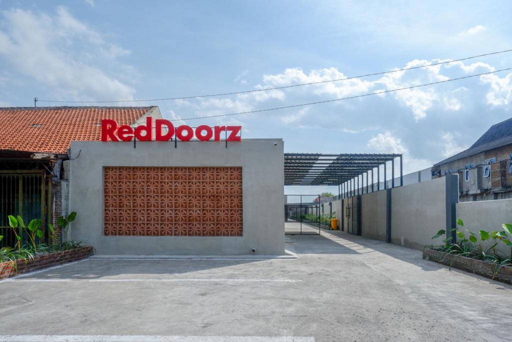un cartello rosso sulla porta sul lato di un edificio di RedDoorz @ Klaten City a Klaten