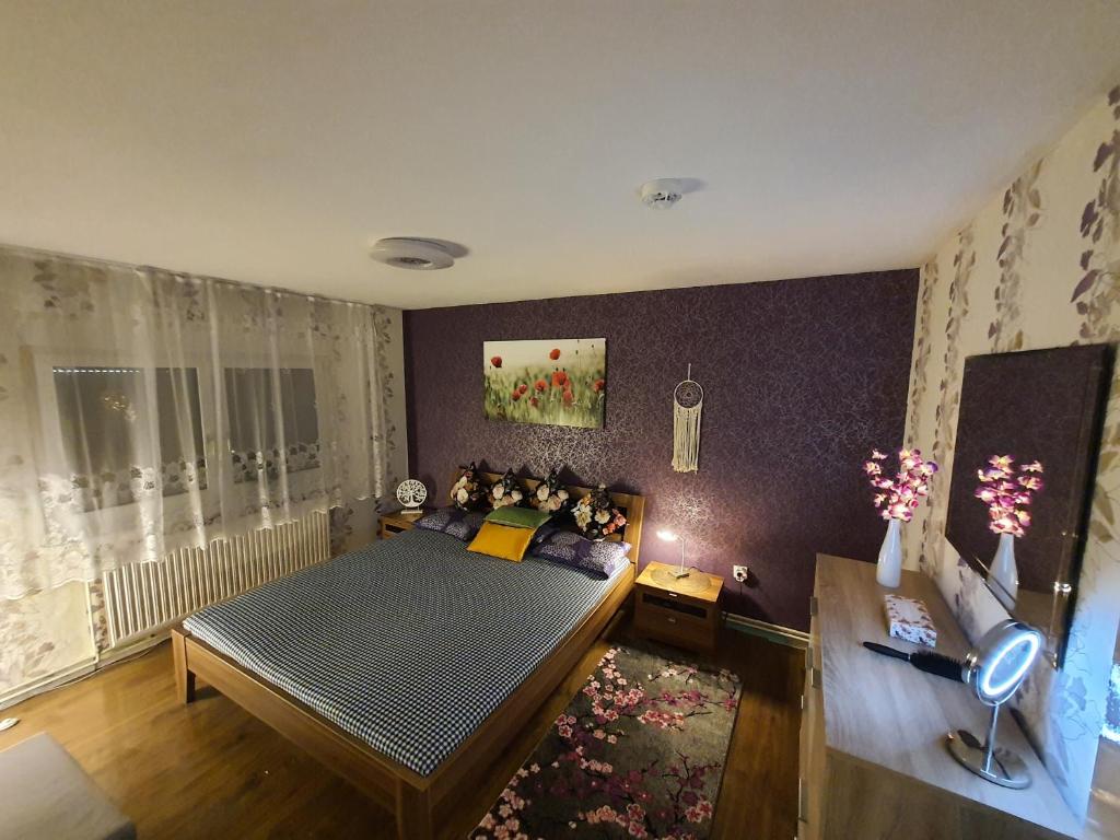 Vöhrenbach的住宿－2 Bedroom Apartment with Terrace & Beautiful View，一间卧室配有一张床和紫色的墙壁