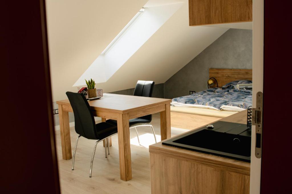 eine Küche und ein Esszimmer mit einem Tisch und einem Bett in der Unterkunft Apartamenty Jordanów - Stacja Paliw MOYA in Jordanów